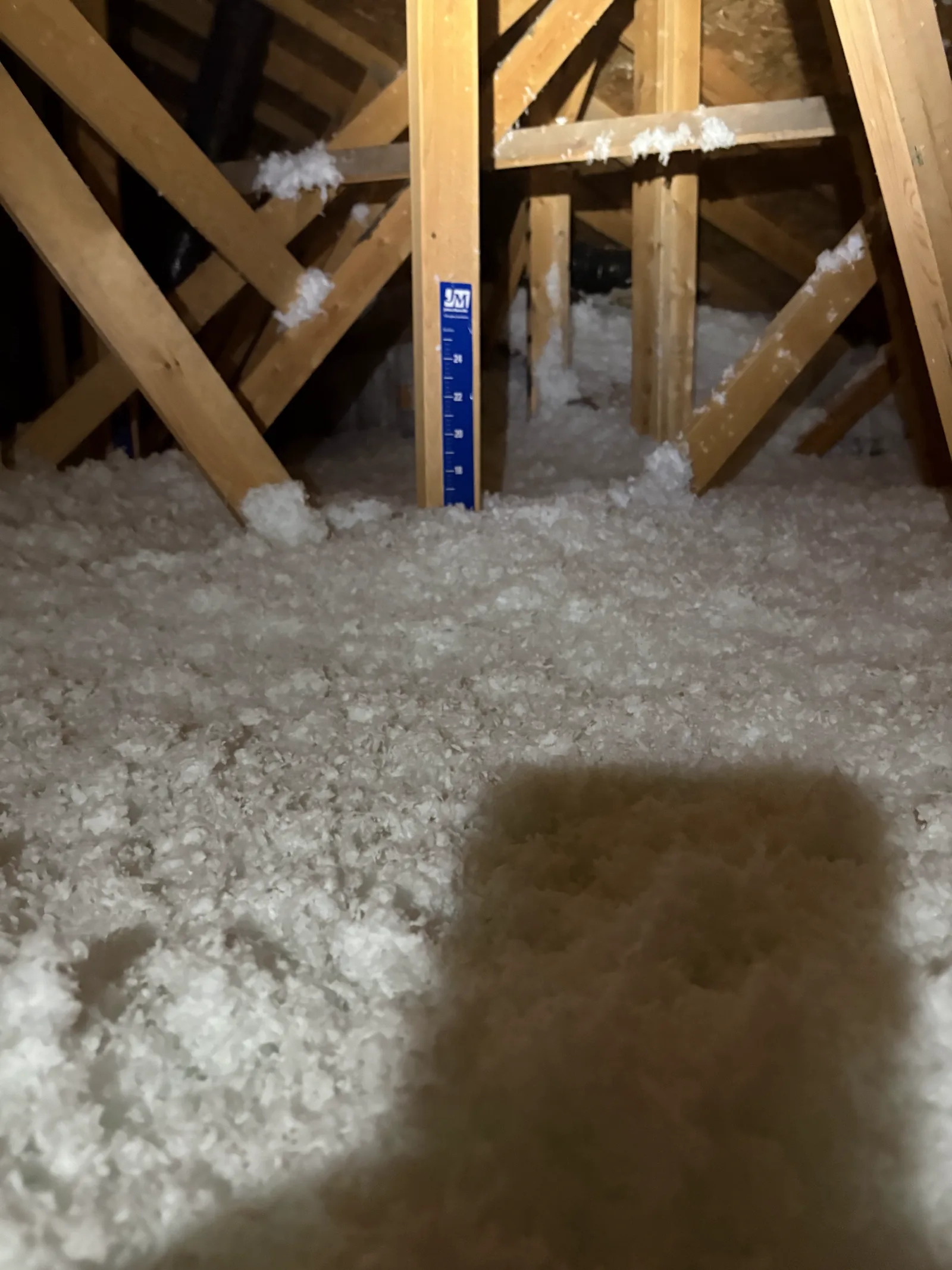 Blown-in insulation at final depth beside the gauge