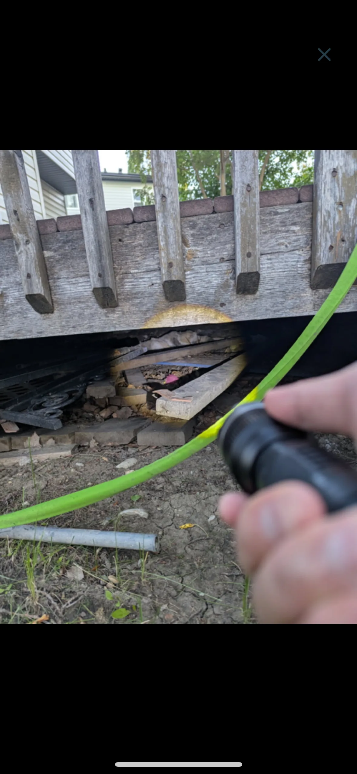 An inspection camera checking beneath a wooden deck