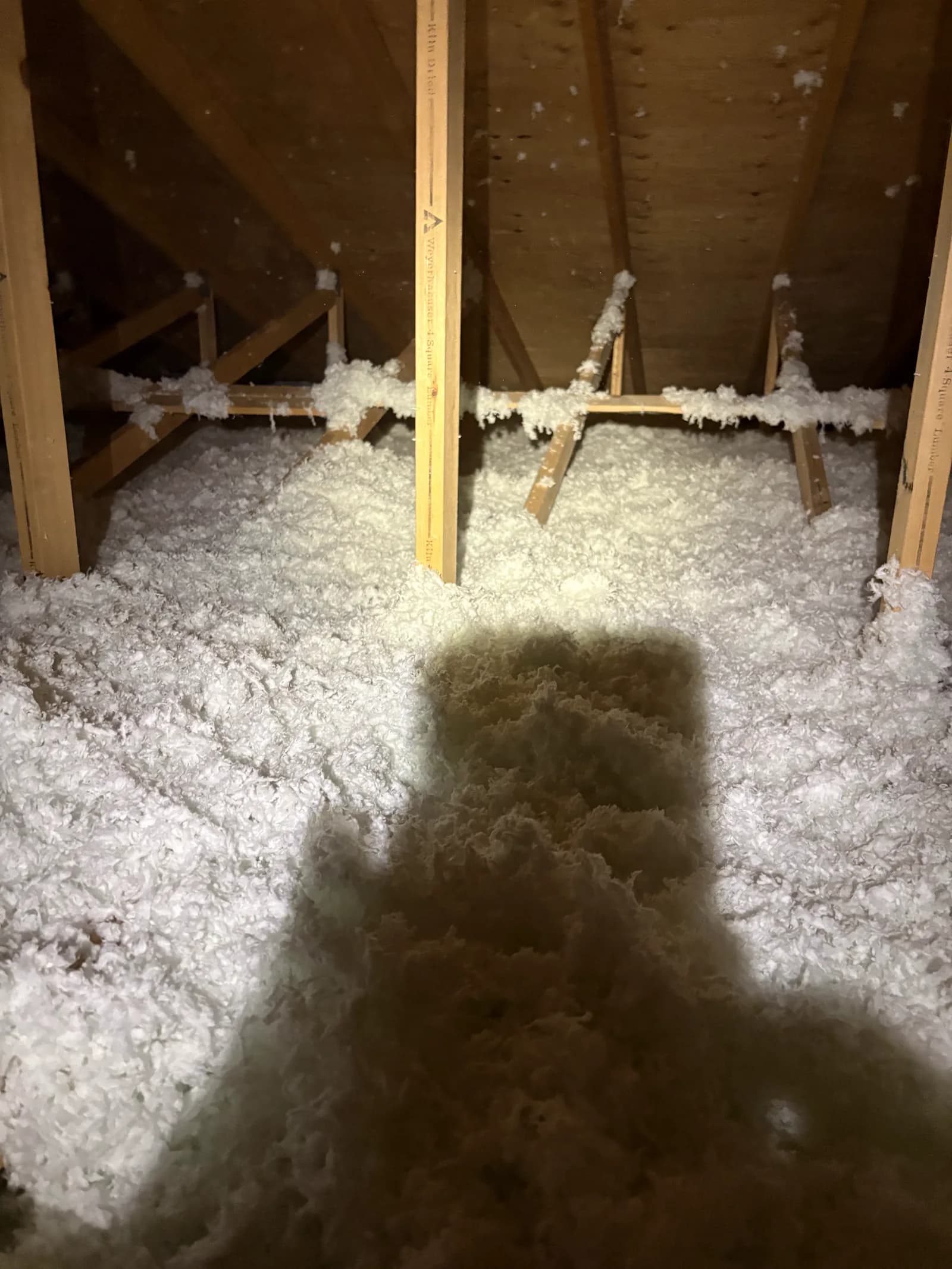 Fresh blown-in insulation across an attic floor
